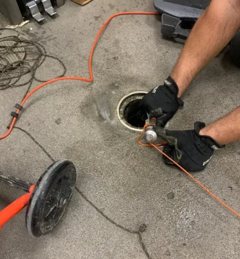 Plumber Inserting a camera into a 4 inch cleanout that leads to the sewer line. This is the beginning of televising a pipe.