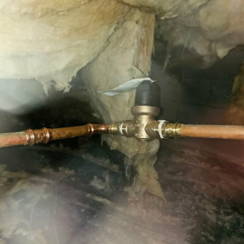 a pressure relieve valves plumbed into a 2/4 inch copper water line in the crawl space of a home