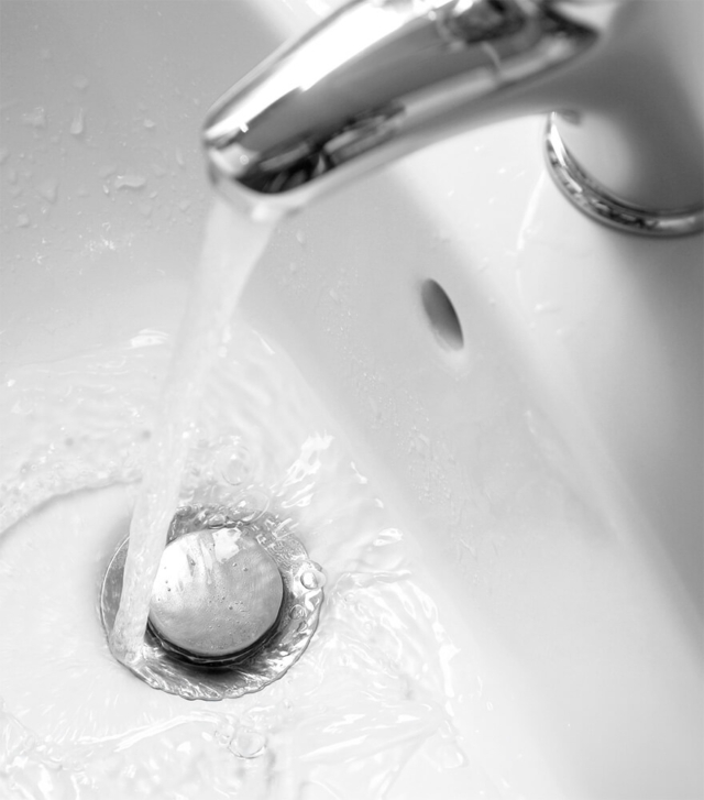 Bathroom sink faucet releasing water into bowl