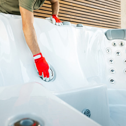 Maintenance worker installing a hot tub and working on a jet