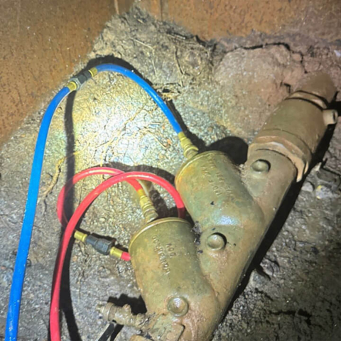 Backflows-preventer assembly in a vault in the ground with test hoses attached.