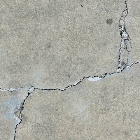 Large cracks in a concrete slab foundation, a key indicator of potential underground slab leaks that require professional plumbing diagnostic services.
